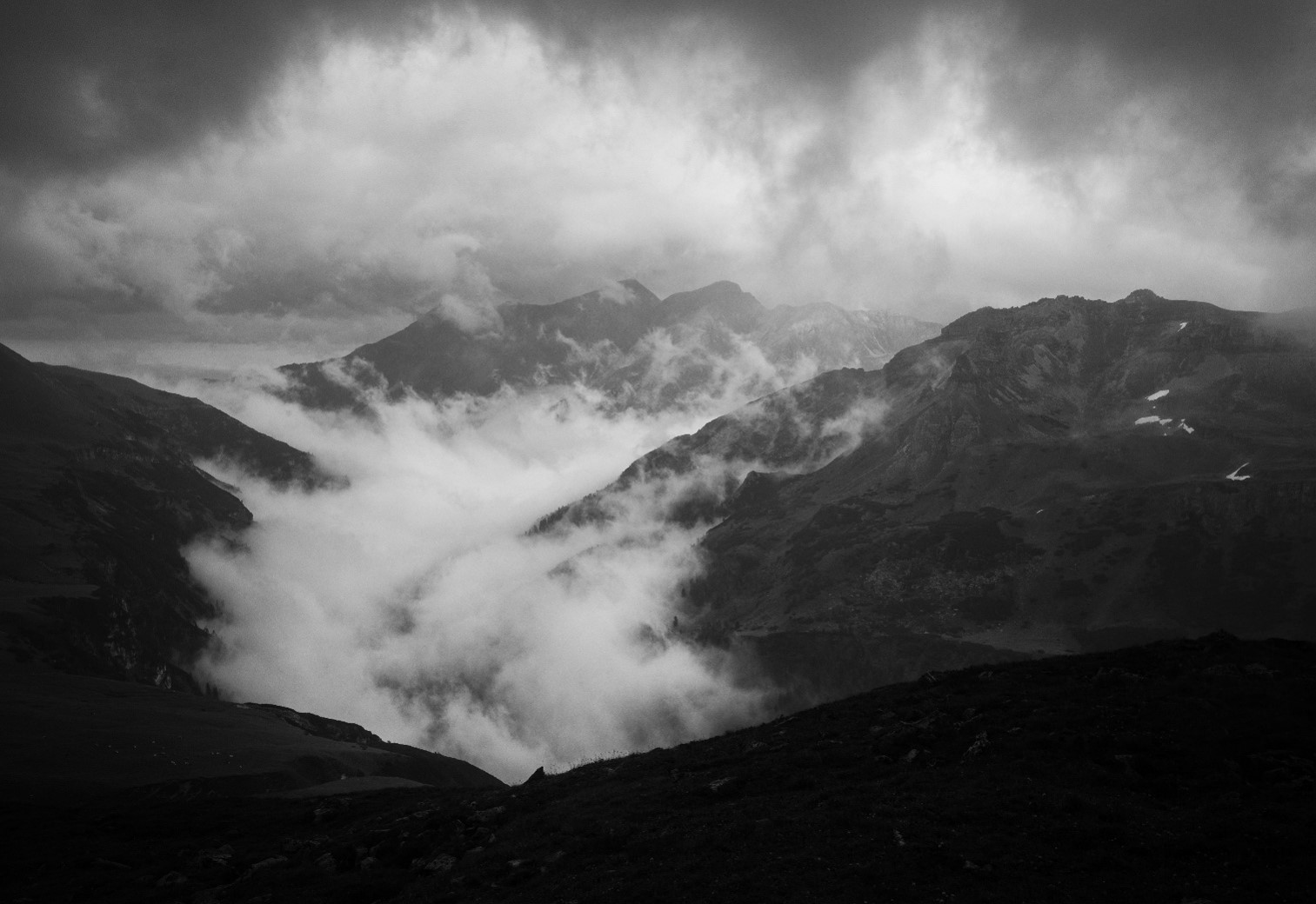 des nuages accrochent la montagne noire
